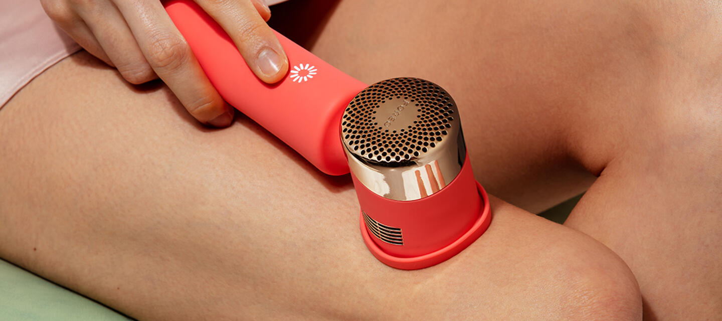 IPL targets melanin in the hair follicle to stop hair from growing Closeup of woman treating her legs with IPL hair removal device PEACH 2 in peach color